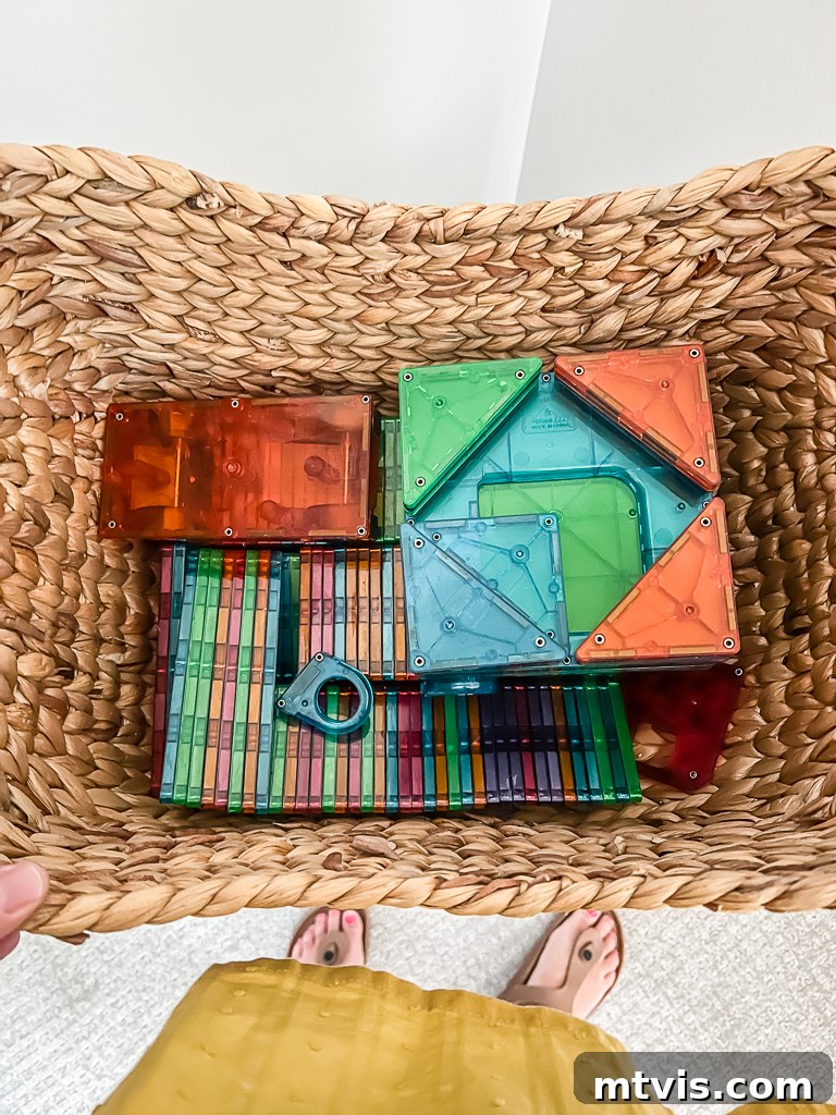Transform Your Playroom: Simple Storage for a Clutter-Free Zone 13 A textured storage basket filled with colorful Magnatiles, showcasing an effective solution for oddly shaped toys in a playroom.