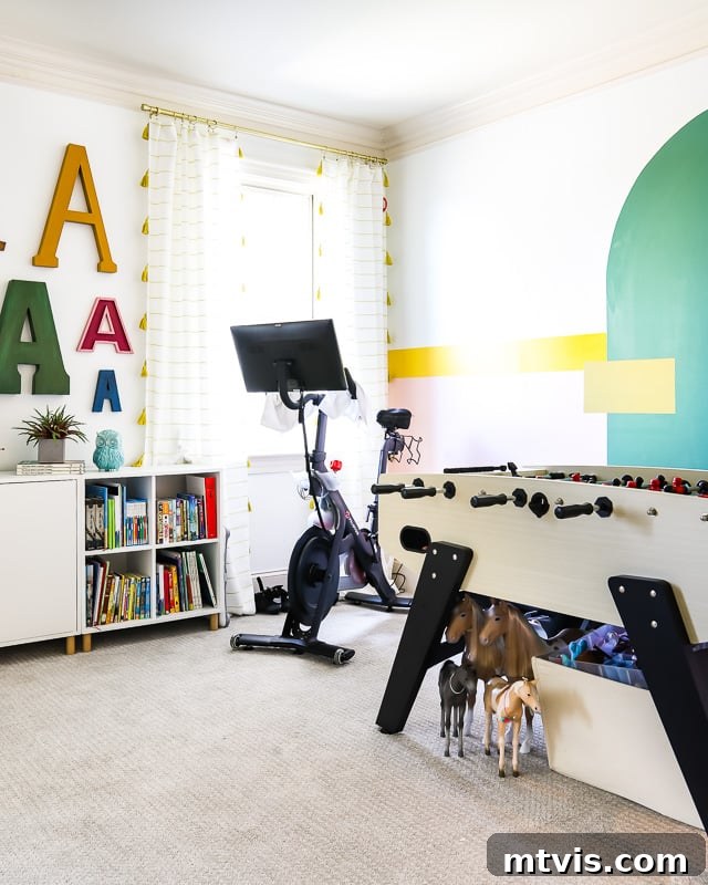 Transform Your Playroom: Simple Storage for a Clutter-Free Zone 15 A family bonus room with a foosball table, where a canvas bin for doll clothes and accessories is creatively stored underneath, demonstrating practical playroom storage.