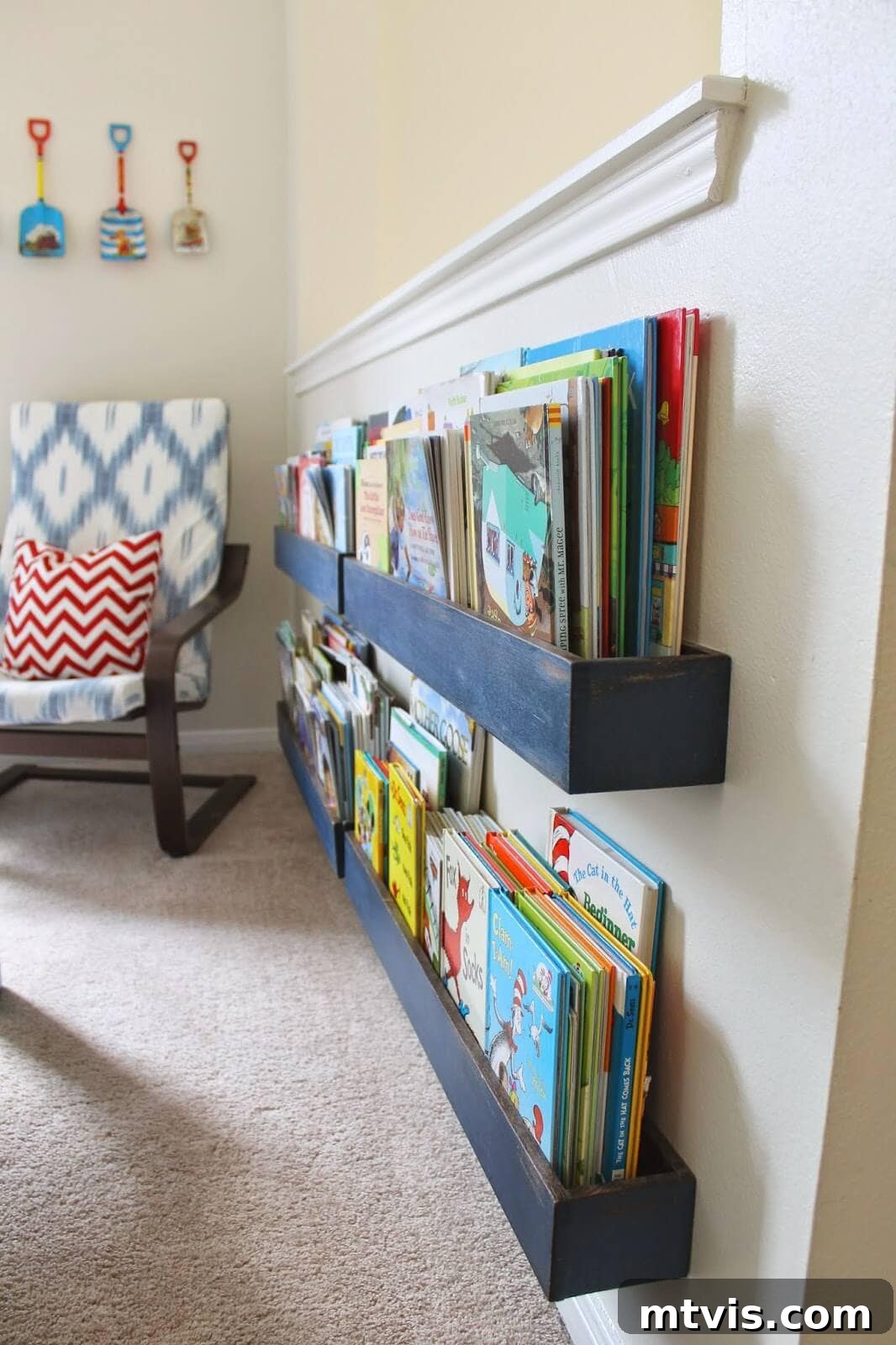 Transform Your Playroom: Simple Storage for a Clutter-Free Zone 16 A wall-mounted bookshelf displaying children's books with their covers facing out, a visually appealing and accessible playroom storage idea.