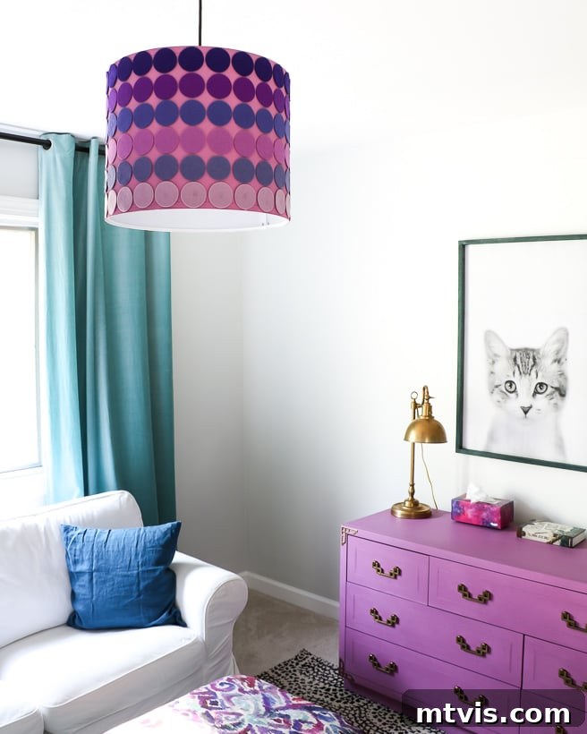 The Big Reveal: Avery's Bespoke Bunk Bed Room 4 The corner of a girl's bedroom has long teal curtains, a purple shade chandelier, purple drawers and a light grey couch.