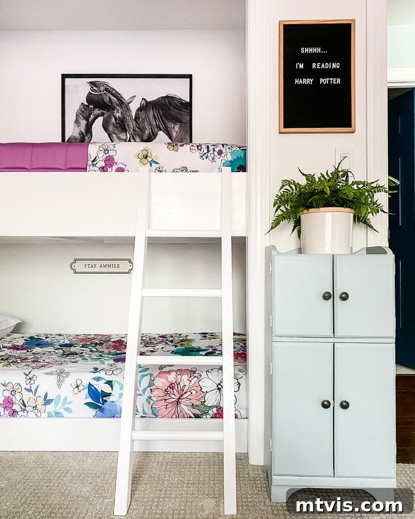 The Big Reveal: Avery's Bespoke Bunk Bed Room 8 Built-in bunk beds in a girl's bedroom have a white ladder, a tall set of cabinets and a sign that reads,