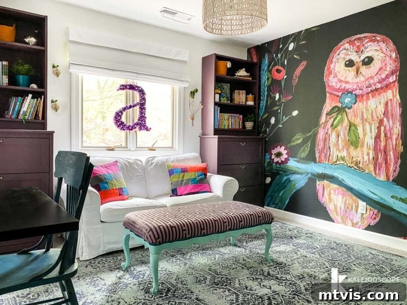 The Big Reveal: Avery's Bespoke Bunk Bed Room 9 A girl's bedroom has a large colorful wall mural of an owl, as well as a white couch, ottoman, desk and cabinets with bookshelves.