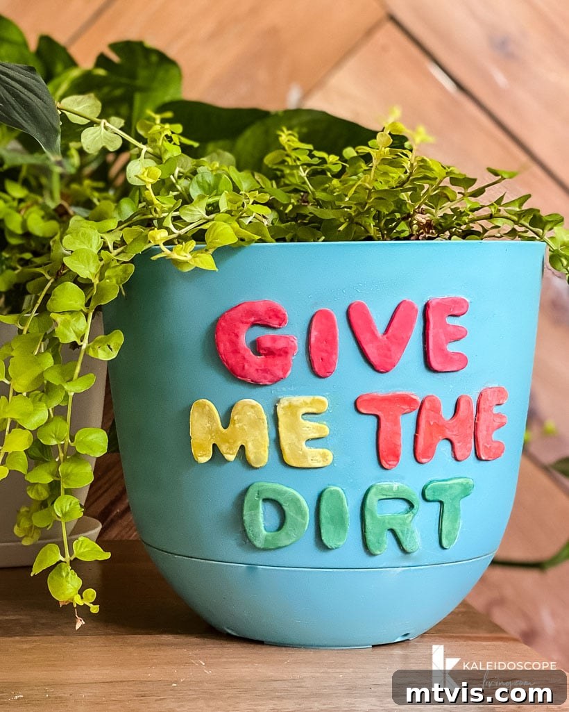 Beyond Basic Pots Polymer Clay Decorating with a Touch of Humor 11 Close-up of a white plant pot adorned with colorful polymer clay shapes, highlighting intricate details.