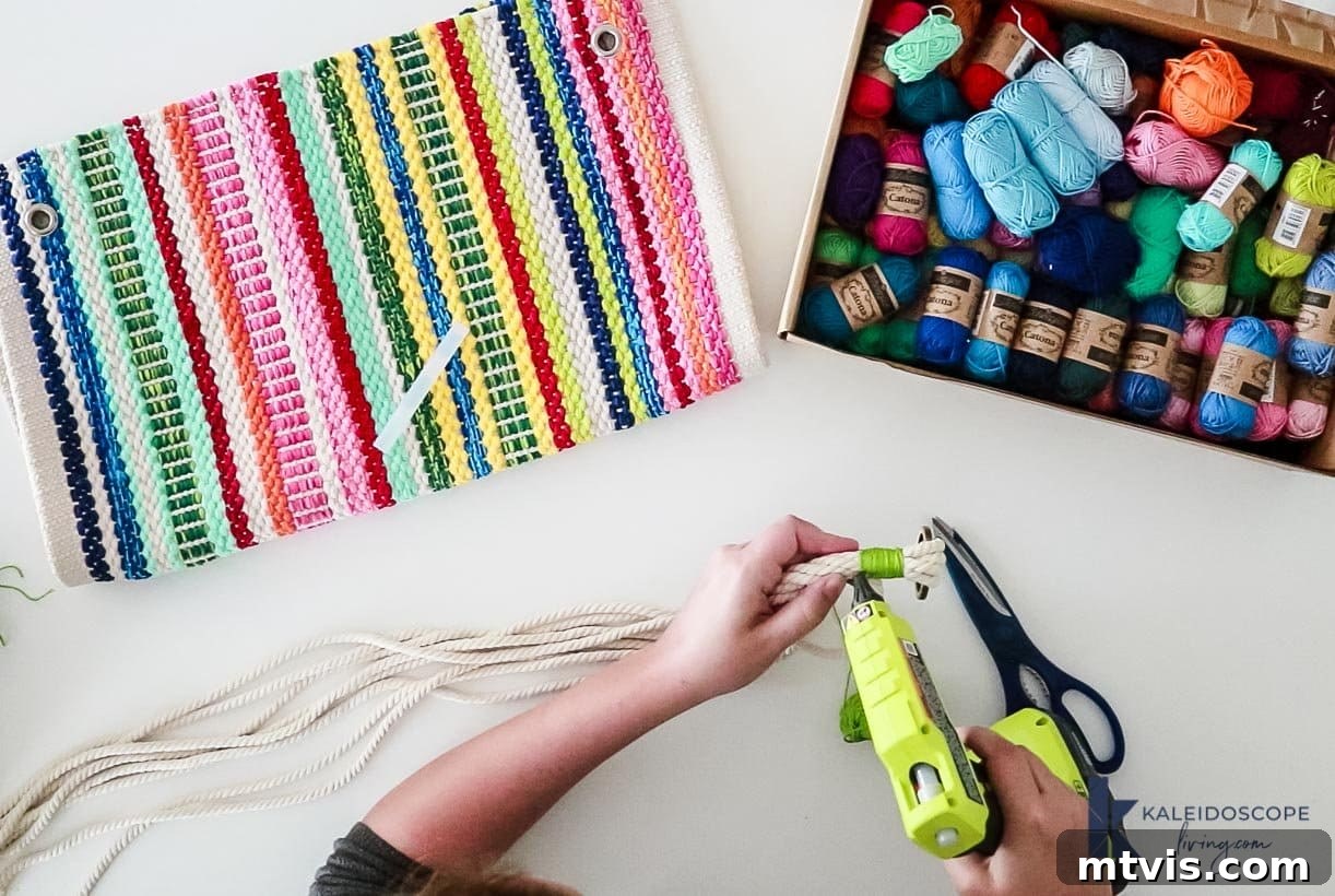 Knot Your Own Macrame Plant Hanger 4 Applying hot glue with a glue gun to secure yarn on a DIY macrame plant hanger.