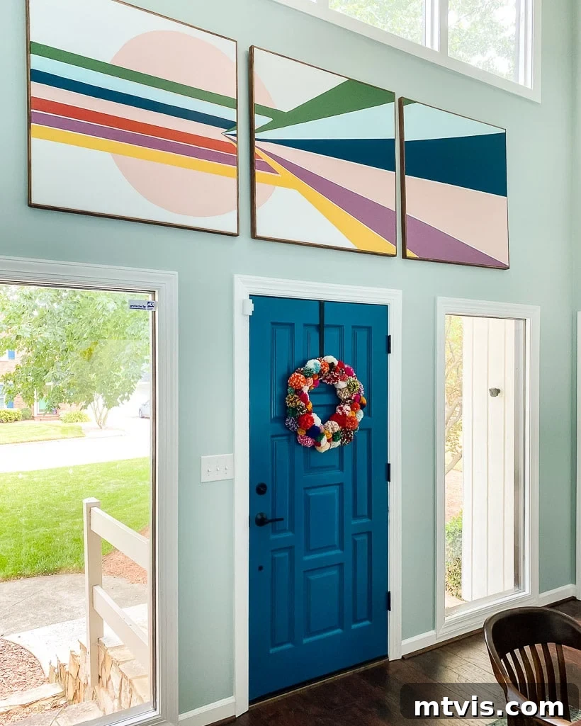 Colorful DIY pom pom wreath hanging on a door, adding year-round cheer.