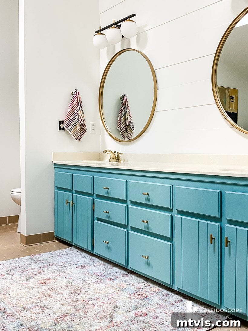 Master Bathroom Remodel on a Budget The Big Reveal 10 turquoise painted vanity - The newly painted turquoise vanity with modern hardware and lights in the transformed master bathroom.
