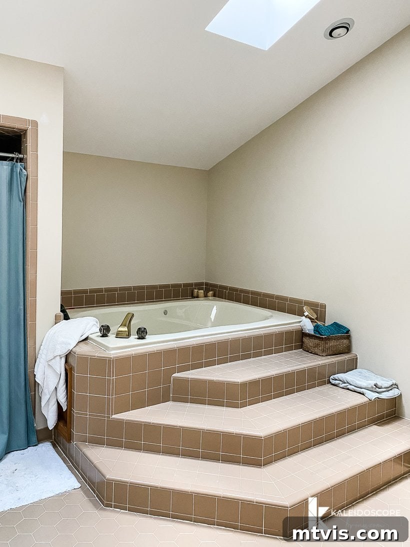 Master Bathroom Remodel on a Budget The Big Reveal 7 brown tile bathtub with stairs - The uninspired brown tiled bathtub area with prominent steps, before renovation.