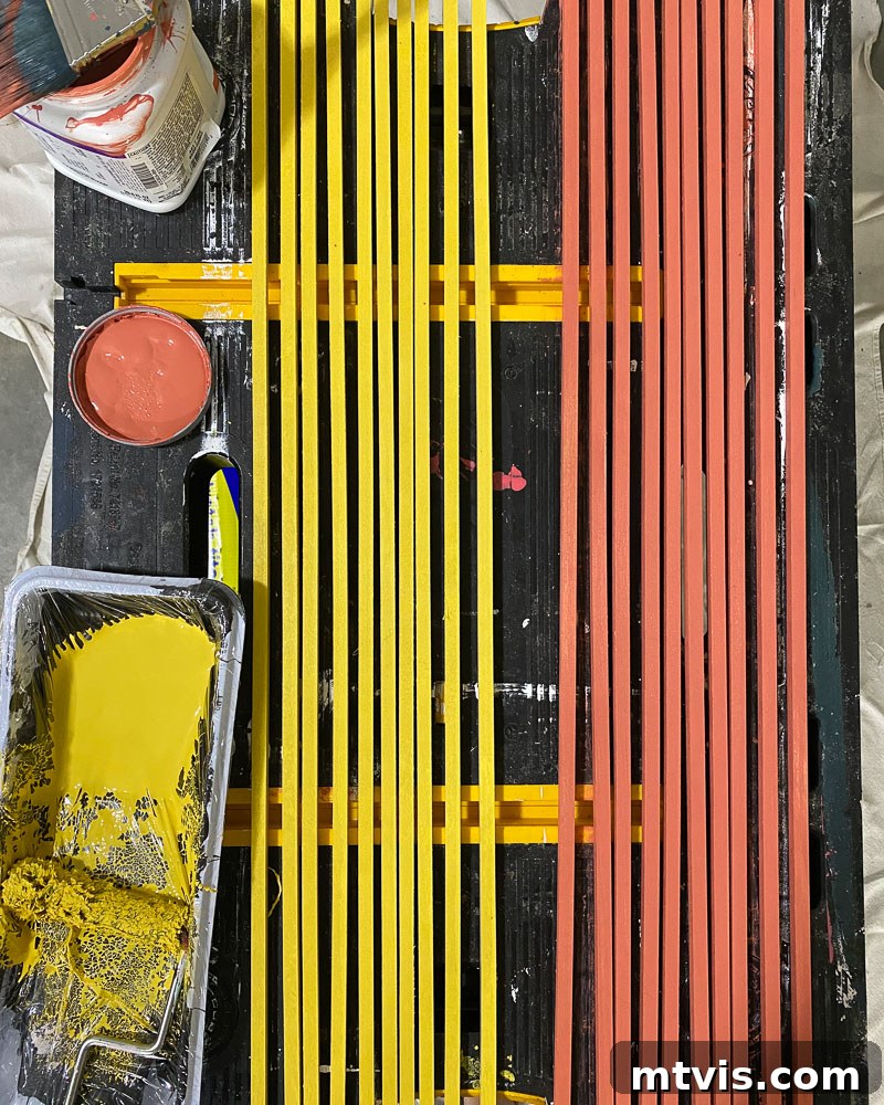 Modern Wood Slat Wall Transformation 4 Carefully painting wood dowels in vibrant colors for the DIY wood slat wall project