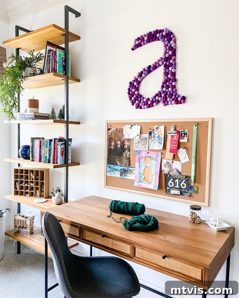 A cozy corner of the mid-century modern girl's room, showing a comfortable bed with colorful pillows and personal touches.