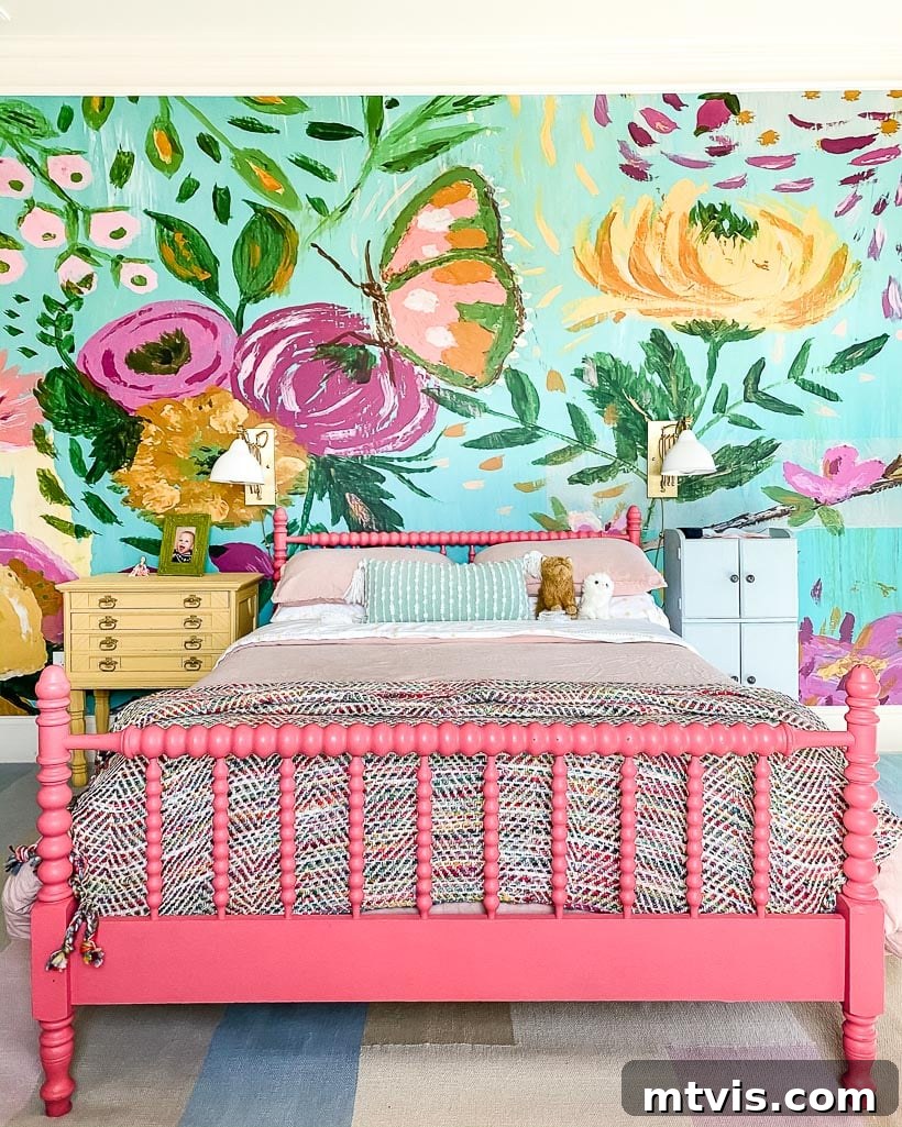 A colorful girl's room featuring painted vintage furniture, a floral wall mural, and vibrant bedding.