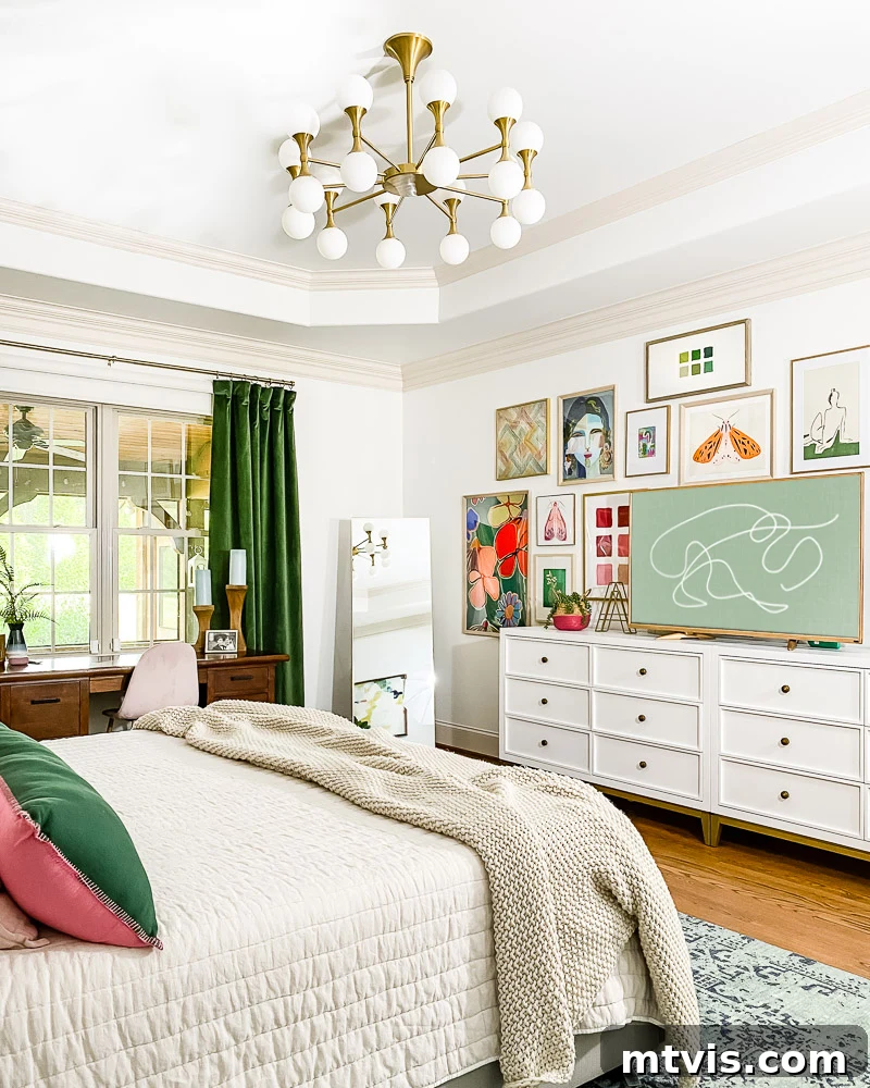 Our Primary Bedroom Design Dilemmas 5 After: Primary bedroom with white dressers, a vibrant gallery wall around a frame TV, and bold green velvet curtains