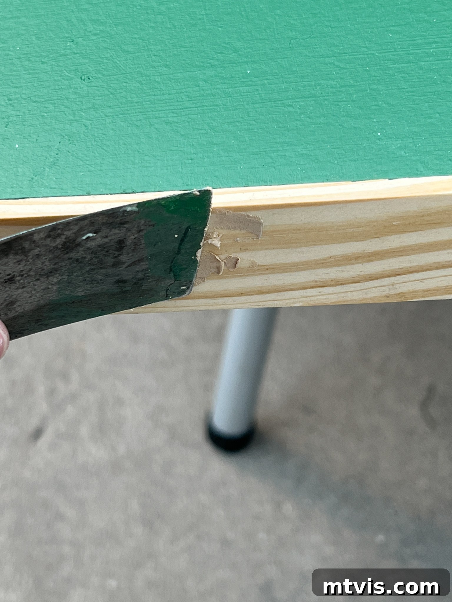 Wood filler applied to nail holes on the art frame, ready for sanding
