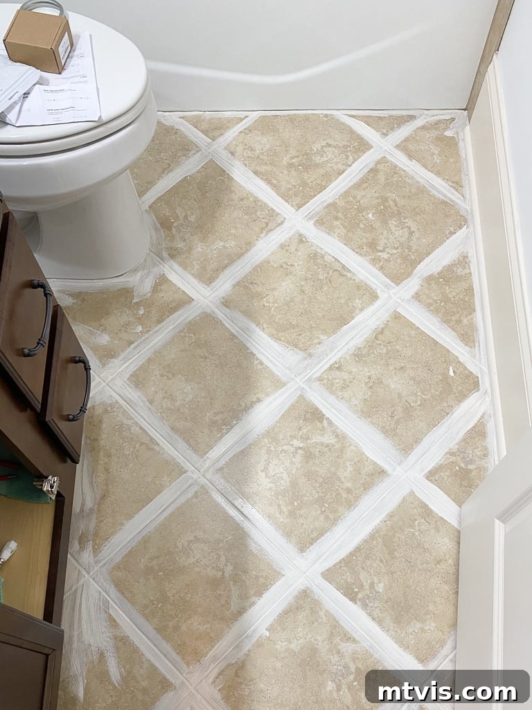 Painted grout lines in a bathroom floor being prepped for tile sticker installation, showing a neat and refreshed appearance.
