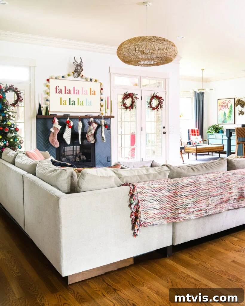 A Spectrum of Holiday Cheer: Our 2021 Christmas Home Tour 8 A festive family room decorated for Christmas, featuring a beautifully renovated fireplace and a Frame TV displaying holiday art.