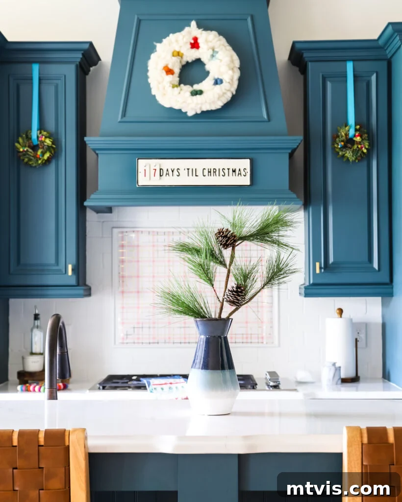 A Spectrum of Holiday Cheer: Our 2021 Christmas Home Tour 4 Blue kitchen adorned with elegant Christmas decorations, featuring a festive backsplash accent.