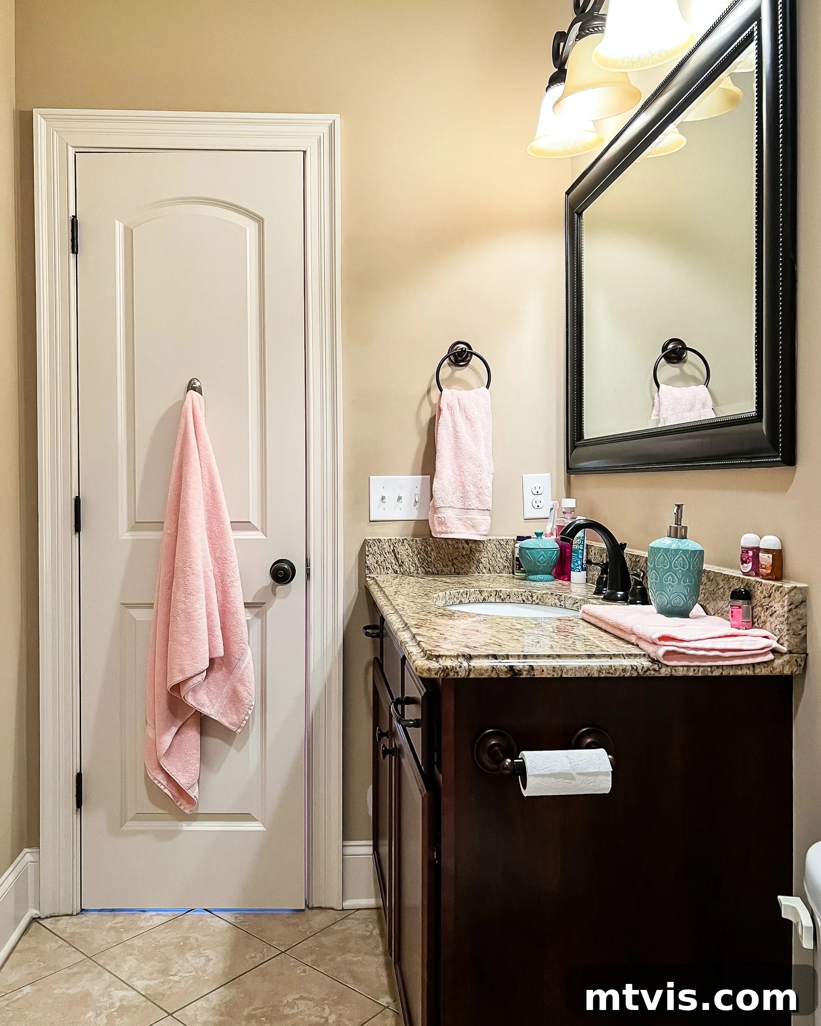 The "before" picture of an outdated bathroom with brown walls and dark wood vanity with beige walls. Paint is essential when doing a bathroom makeover on a budget.