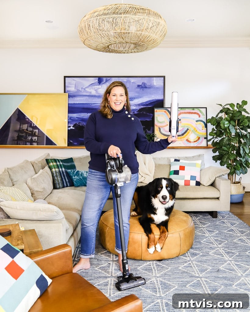 Woman with a cordless vacuum cleaner next to a Bernese Mountain Dog, demonstrating quick cleaning.