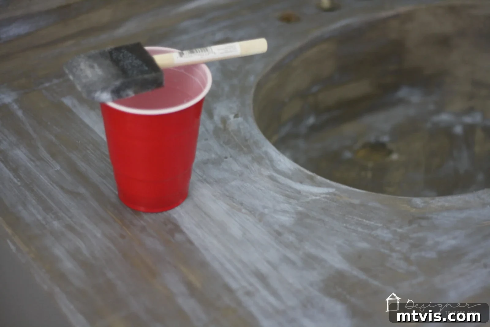 Effortless DIY Concrete Vanity and Sink No Forms No Heavy Lifting 11 A hand applying a clear, milky concrete sealer to a freshly finished concrete vanity top, demonstrating the protective final step.