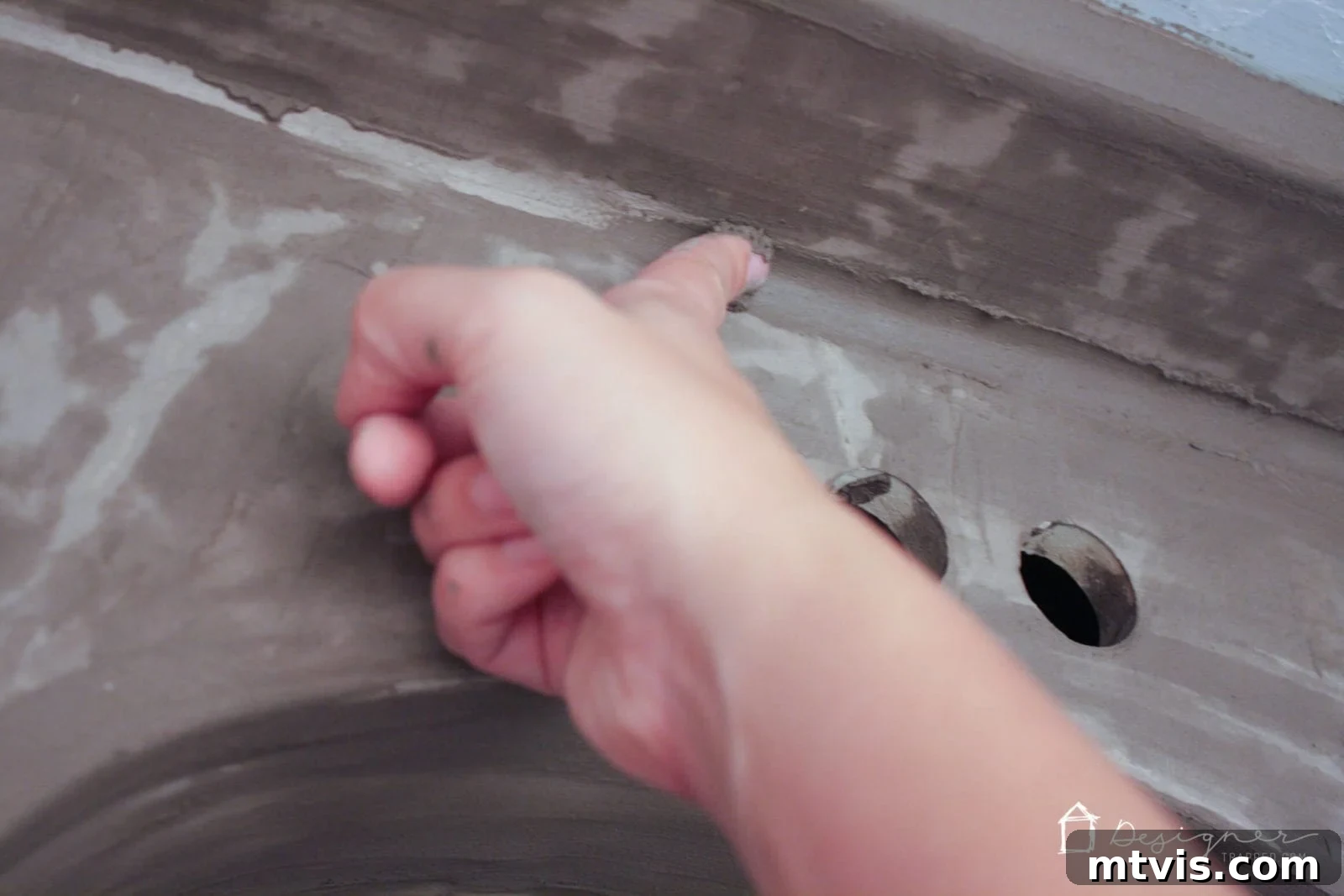 Effortless DIY Concrete Vanity and Sink No Forms No Heavy Lifting 8 A close-up of a partially dried second coat of concrete overlay on a vanity, showing a splotchy texture before further refinement.