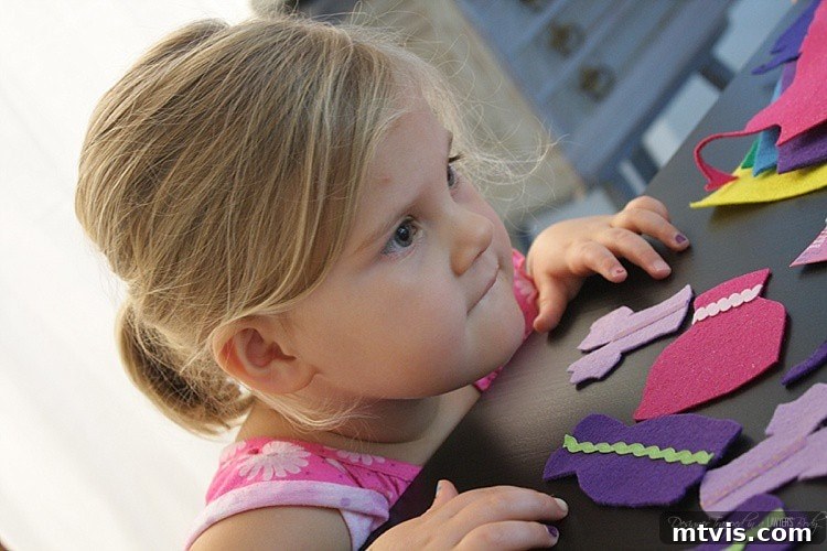 Felt Doll Magic: Create Your Own Playtime Friends 6 A child's hands carefully selecting felt pieces, demonstrating the fun and engaging nature of creating DIY dress-up dolls.
