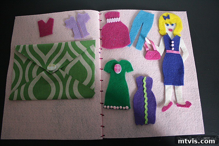 Felt Doll Magic: Create Your Own Playtime Friends 12 Two finished DIY felt dress-up dolls with a variety of outfits and a personalized felt storage book, showcasing a completed craft project.