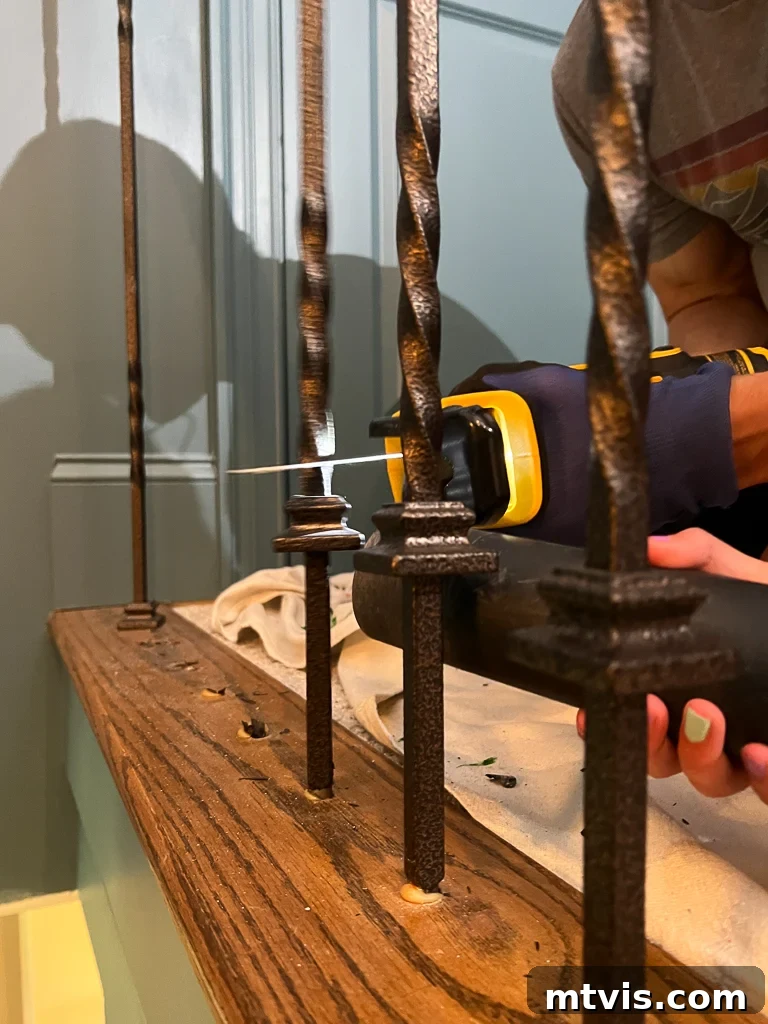 Stair Railing Makeover Replace Balusters for a Fresh Look 6 removing old iron balusters with reciprocating saw