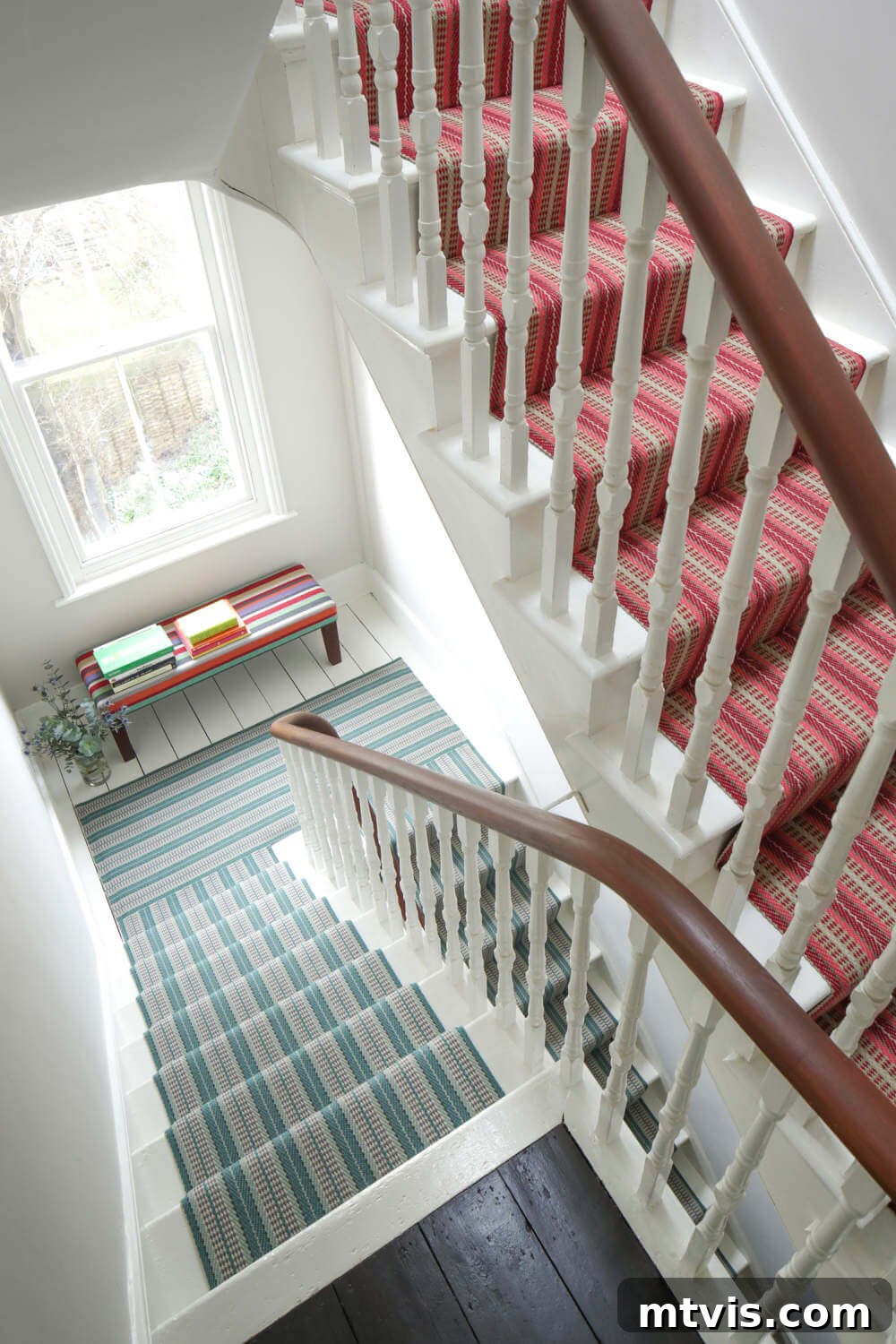 Elevate Your Entryway: Creative Stair Runner Designs 13 Contrasting yet cohesive stair runners adorn a three-story staircase, ingeniously using different colorways of the same pattern to subtly separate and unify the floors.