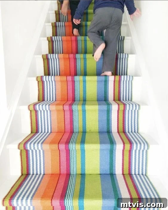 Elevate Your Entryway: Creative Stair Runner Designs 3 A colorful striped staircase runner by Annie Selke creates a fun focal point over clean white stairs, adding warmth and personality to the entryway.