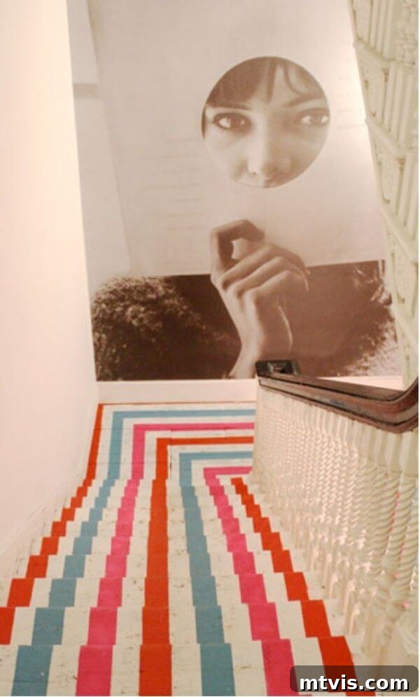 Elevate Your Entryway: Creative Stair Runner Designs 8 A vividly striped, painted stairwell with three distinct colors creating a modern runner effect. A sepia-toned photograph adorns the landing wall, enhancing the artistic atmosphere.