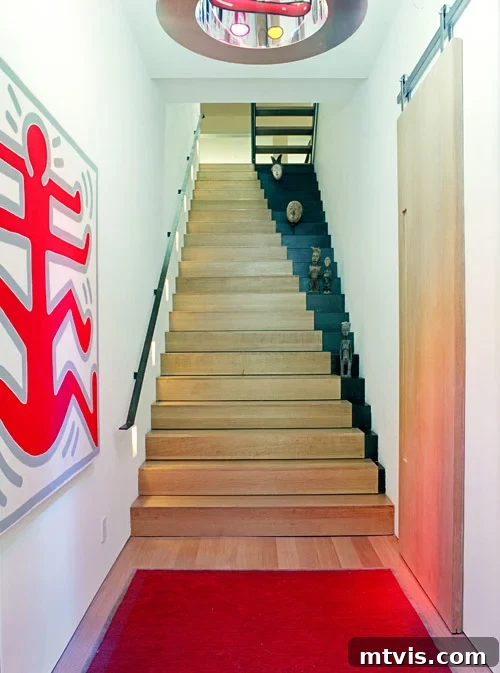 Elevate Your Entryway: Creative Stair Runner Designs 10 An offset painted wood staircase featuring ascending black right sides, creating a captivating optical illusion. Large, abstract graphic art hangs nearby, complementing the modern aesthetic.