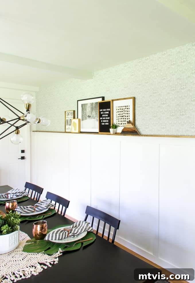 A board and batten wall in white, features a stained wood photo ledge, for a unique dining room gallery. 