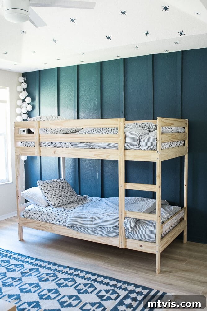 Twin bunk beds in cedar get a stylish complement from the dark blue accent wall and stenciled ceiling stars. 