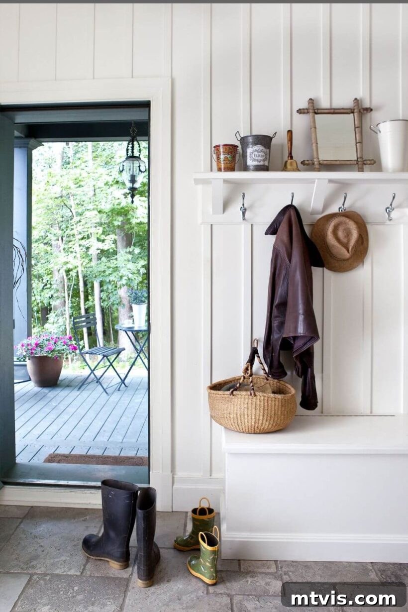 A mudroom looks rustic and inviting with white board and batten walls that expand the vertical space. 