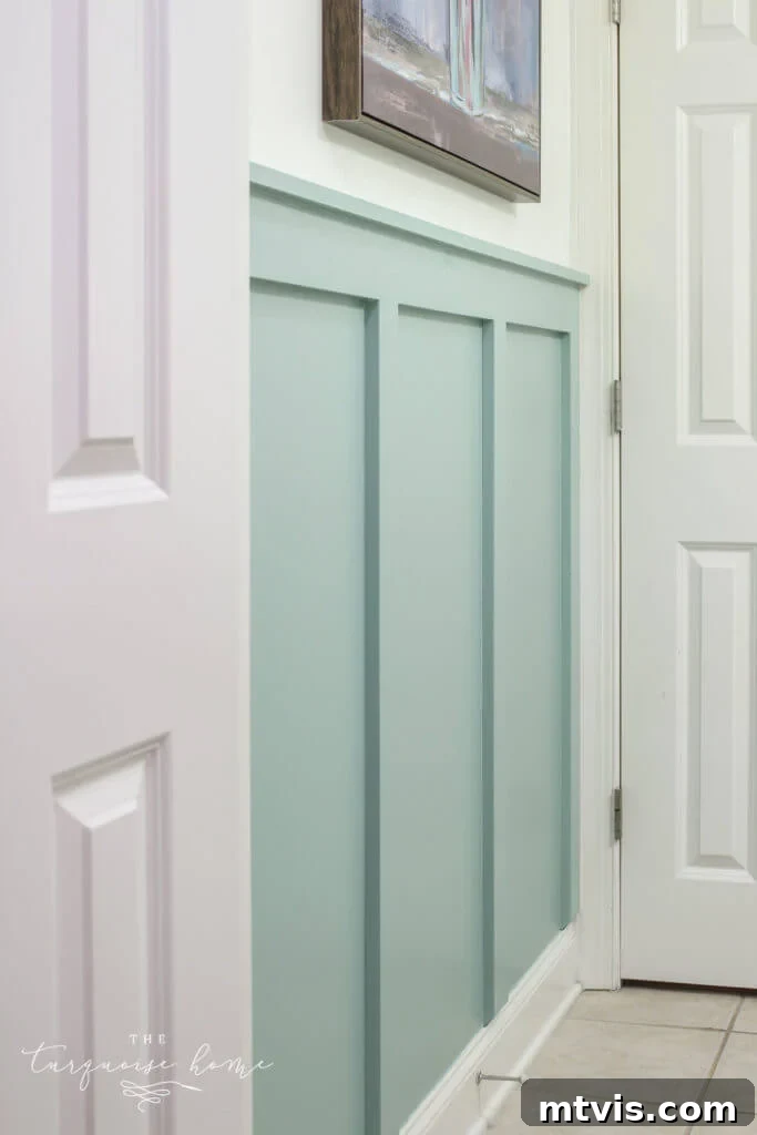A light blue bathroom gets a fresh look from half-way board and batten walls with white trim. 