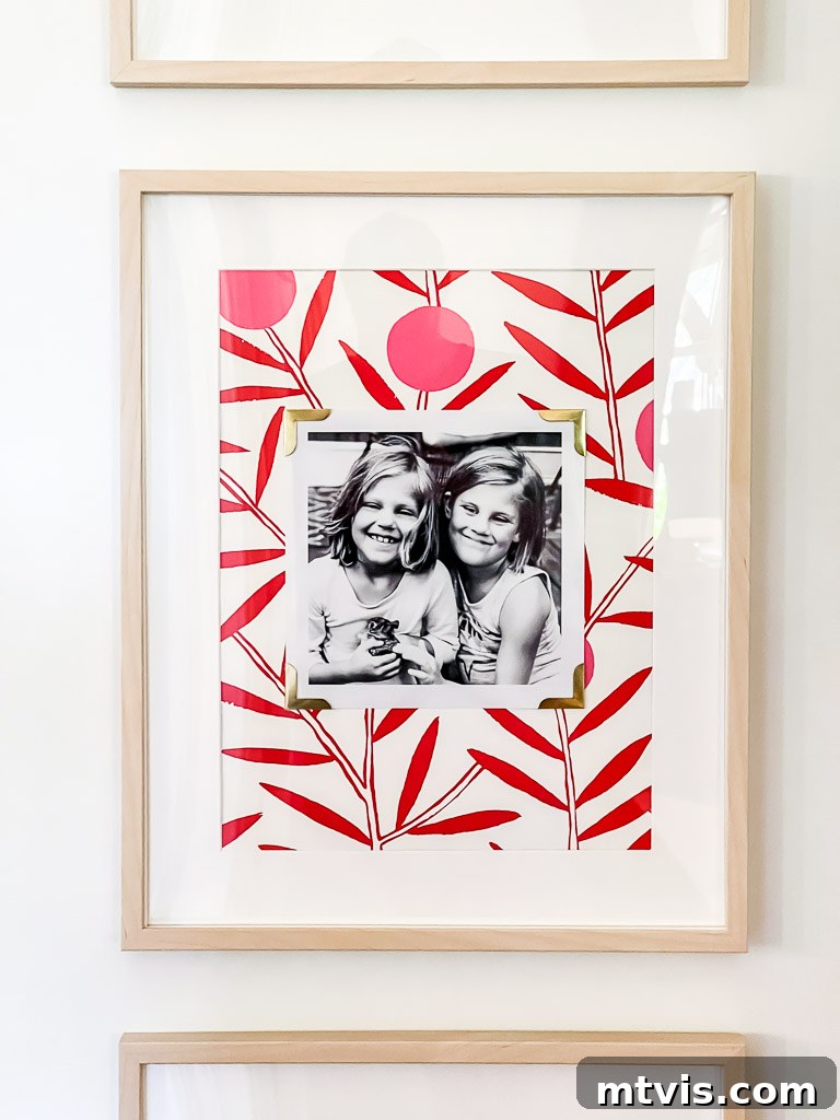 Another close-up shot of a framed family photo, emphasizing the creative use of wallpaper within the frame to add depth and style to the gallery wall.