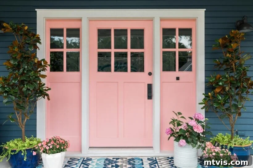 Unlock Your Porch's Potential: Designer Decor Secrets 15 light pink front door on a navy house, flanked by planters with greenery and pink flowers