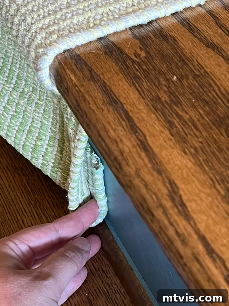 Ultimate Guide to Stair Runner Installation 16 Securing the bottom of the stair runner by folding and stapling the excess fabric against the riser.