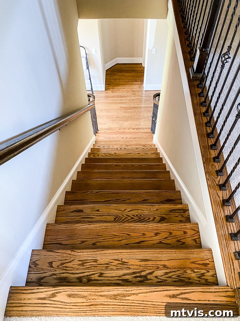 Ultimate Guide to Stair Runner Installation 21 Beige staircase with iron balusters and wood floors, prior to the stair runner installation.