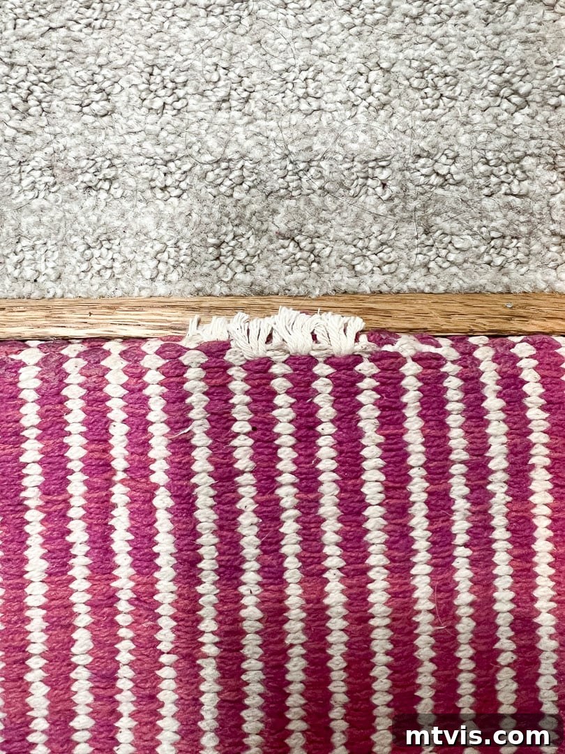 Ultimate Guide to Stair Runner Installation 24 Close-up of slight fraying at the top edge of a DIY stair runner where it meets the carpeted hallway.