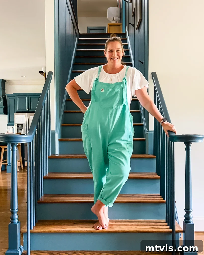Ultimate Guide to Stair Runner Installation 4 Tasha Agruso of Kaleidoscope Living standing on a staircase during makeover, showing new paint and balusters.