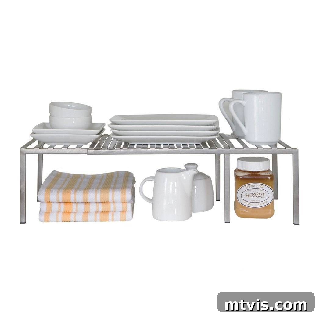 Everyday Kitchen Cabinet Organization 15 A product image of white wire expandable kitchen cabinet shelves with white plates and cups on top and yellow striped towels, milk holder, and bottle of honey.