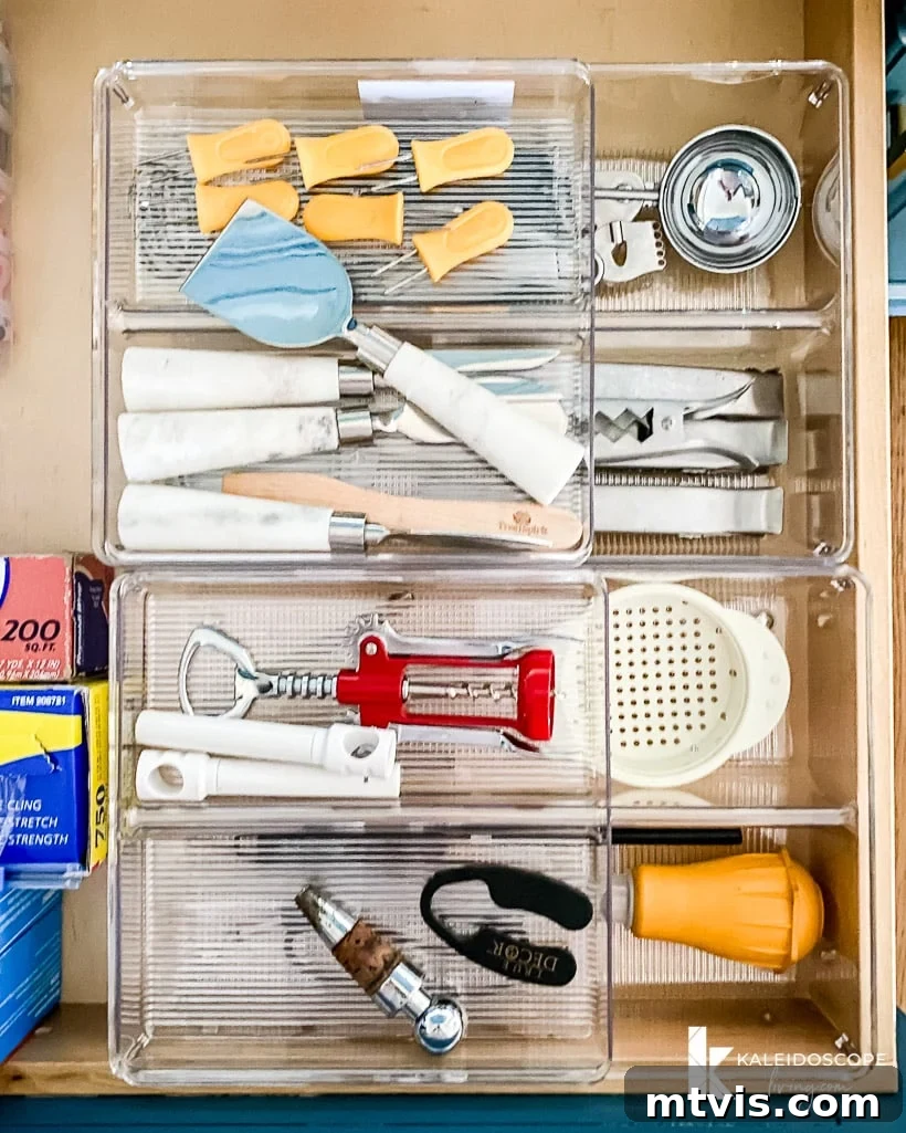Everyday Kitchen Cabinet Organization 8 Space-saving kitchen drawer organization shows a clear shorter organizer on top of a longer clear organizer holding more kitchen utensils like wine openers, corn holders, whisks, clips, ice scoops and more.