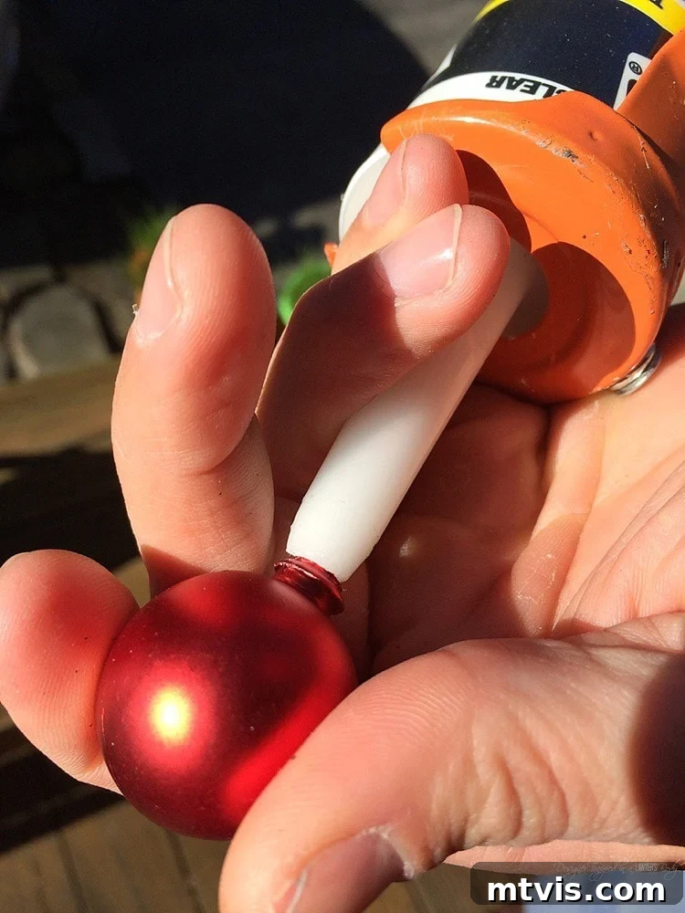 Crafting a Rustic Christmas Reindeer from Logs 9 Using clear caulk to secure the ornament nose on the log reindeer