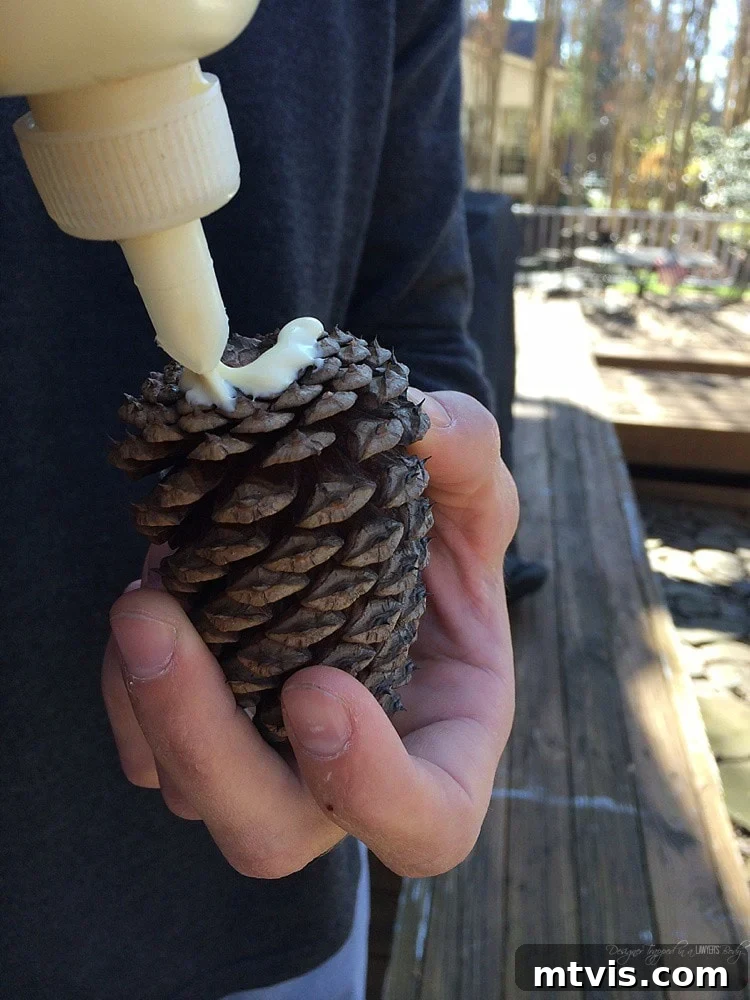 Crafting a Rustic Christmas Reindeer from Logs 10 Gluing a pinecone tail onto the log Christmas reindeer