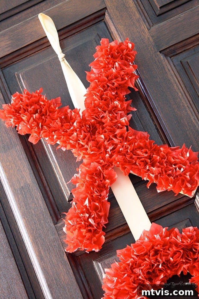 Valentines Door Decor DIY 16 Close-up view of the fluffy red tissue paper texture on the 'X' letter of the DIY wreath.