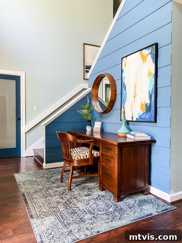 Vibrant blue foyer with a modern plank wall and desk, painted in Behr Blueprint.