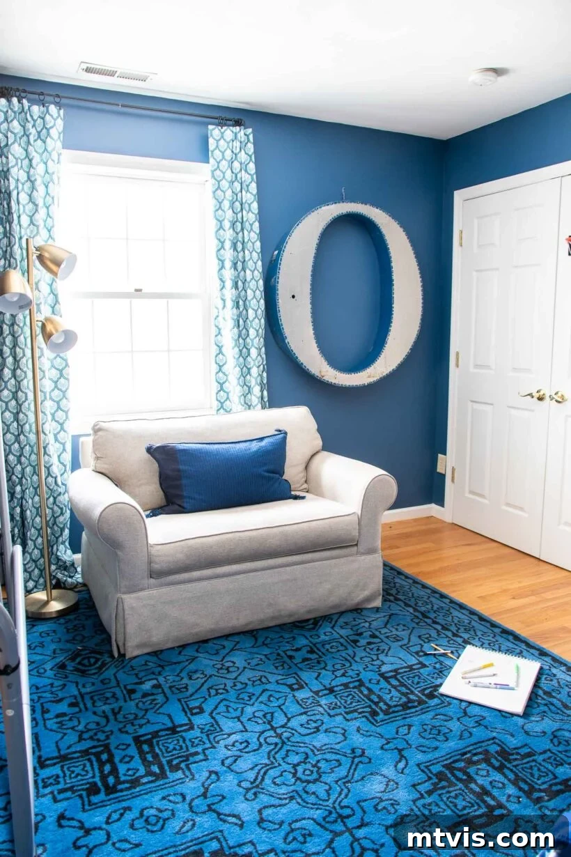 Bright blue walls in a boy's room, painted with Clare Hyperlink, complemented by kid-friendly decor.