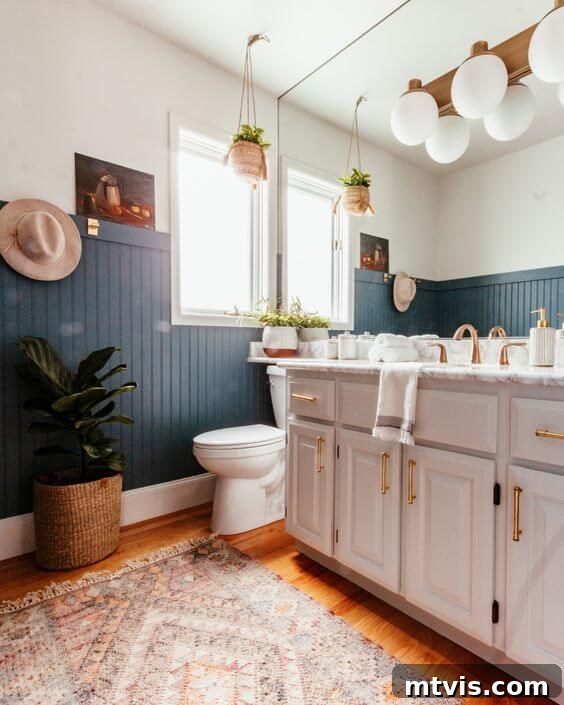 Dramatic blue-green wainscoting in a bathroom, painted with Sherwin-Williams Smoky Blue, complementing white and neutral decor.