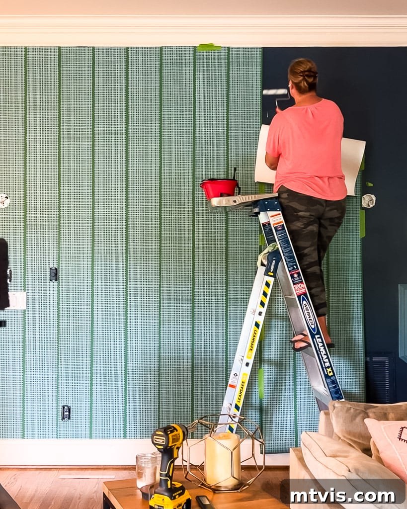 Renter-Friendly Wallpaper: Simple Steps for Easy Removal 7 Applying wallpaper panel, aligning with previous one, using painter's tape for guidance