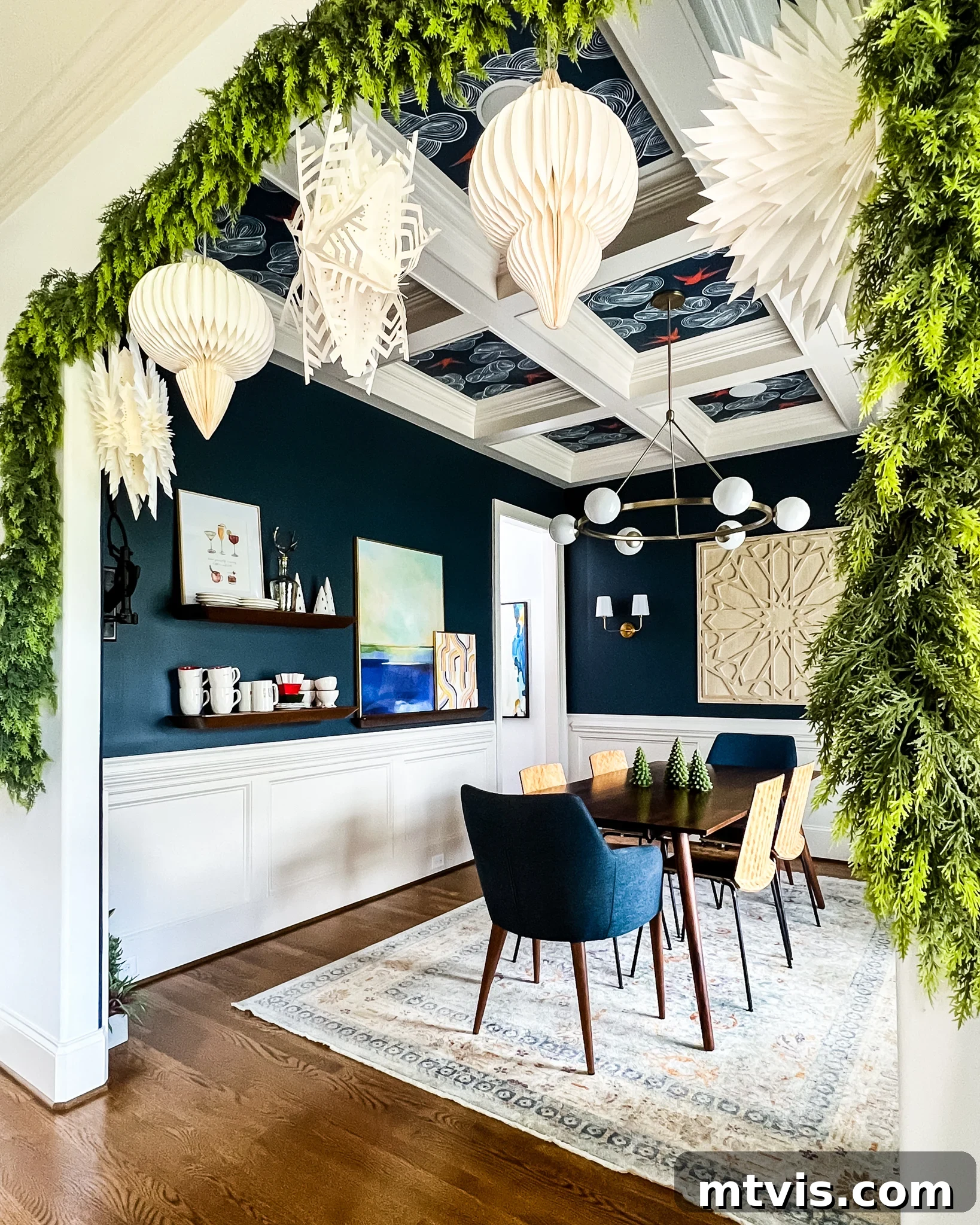 Faux cedar garlands gracefully hanging in the entryway to a dining room, beautifully decorated for the Christmas season.